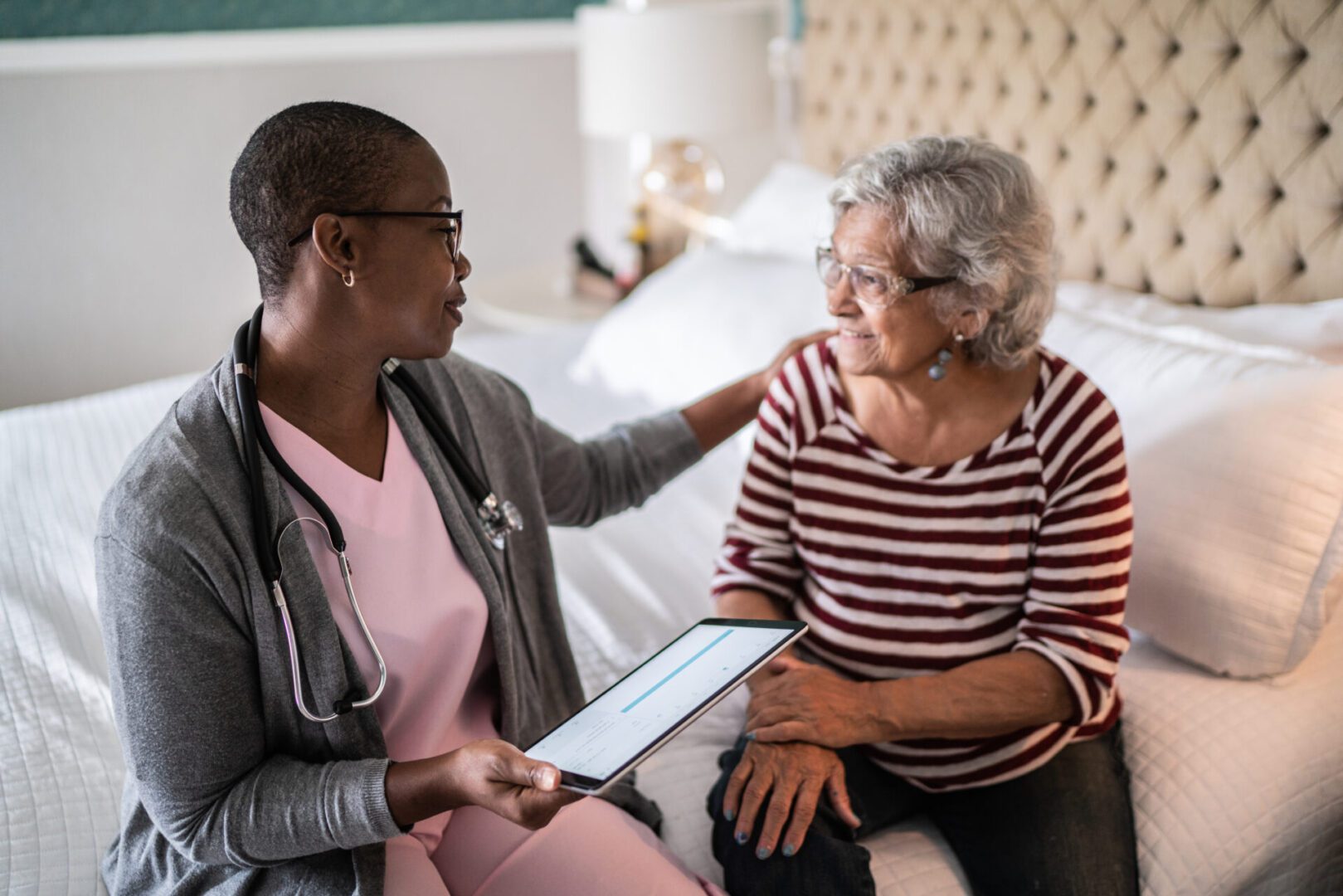 Doctor consulting with elderly woman at home.
