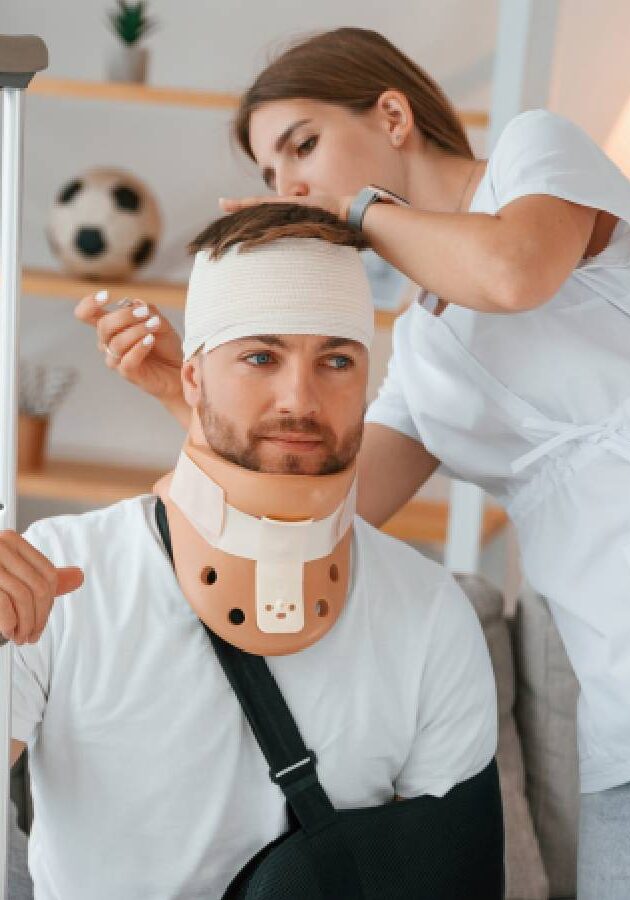 Nurse caring for injured man with neck brace and arm sling.